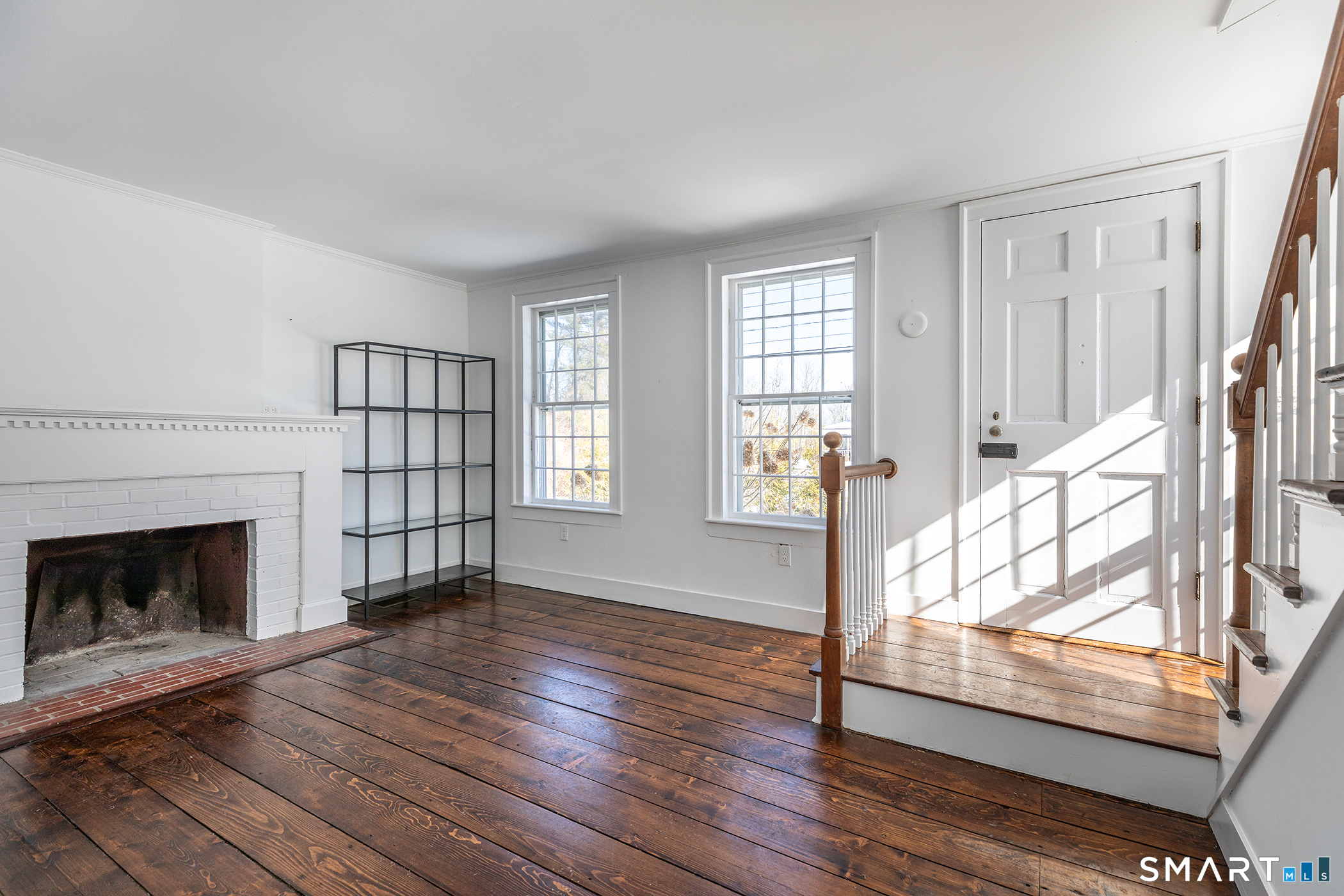 403 Beach Street Litchfield, CT 06759 - Photo 6 of 33 a view of an empty room with wooden floor fireplace and a window
