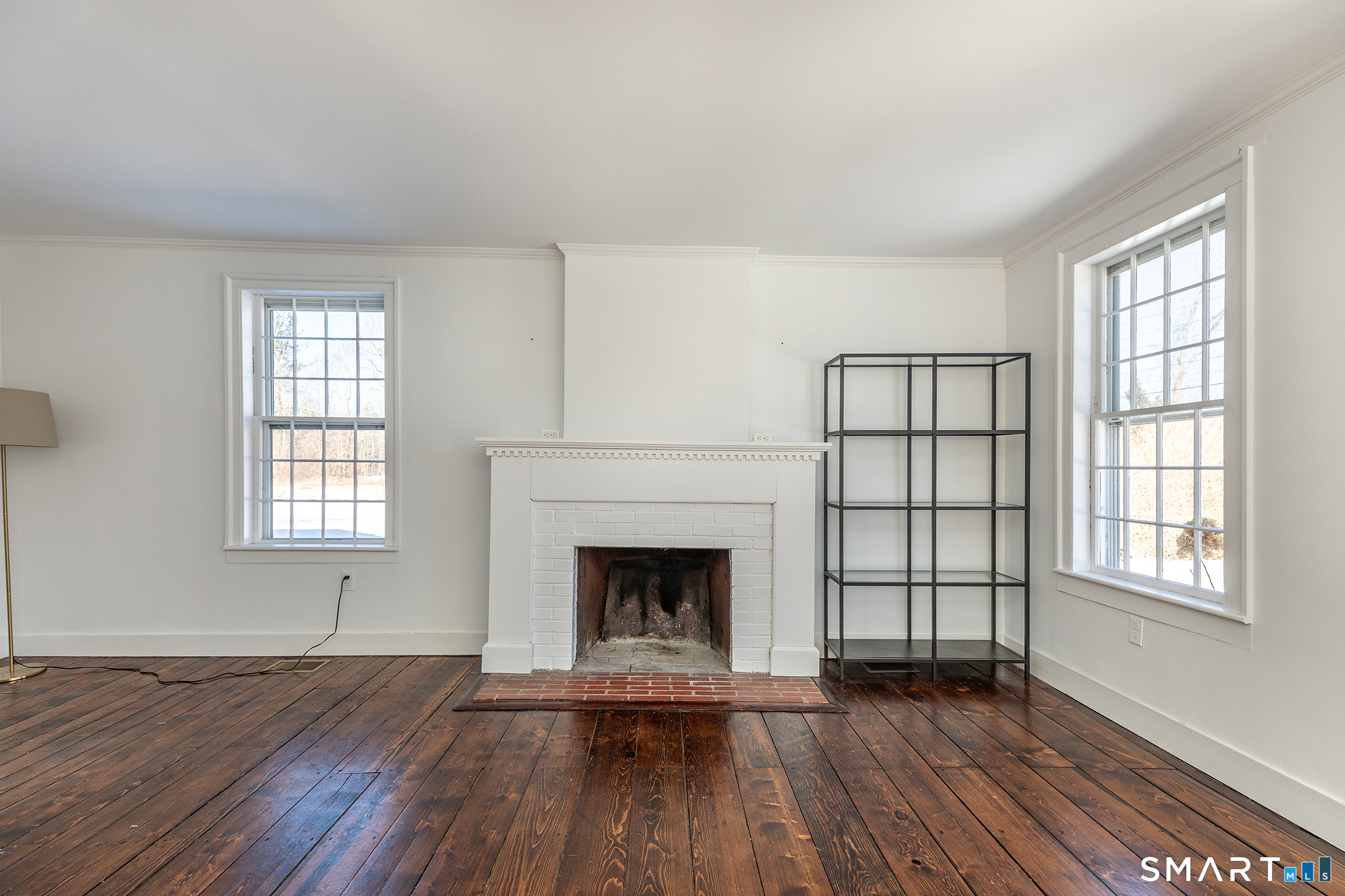 403 Beach Street Litchfield, CT 06759 - Photo 9 of 34 an empty room with wooden floor fireplace and windows