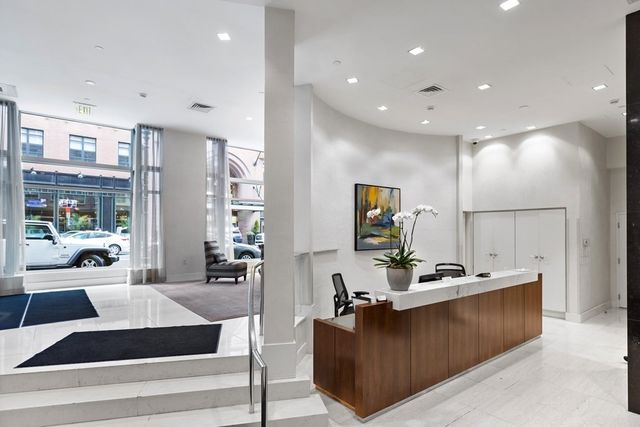 a living room with furniture kitchen view and a large window