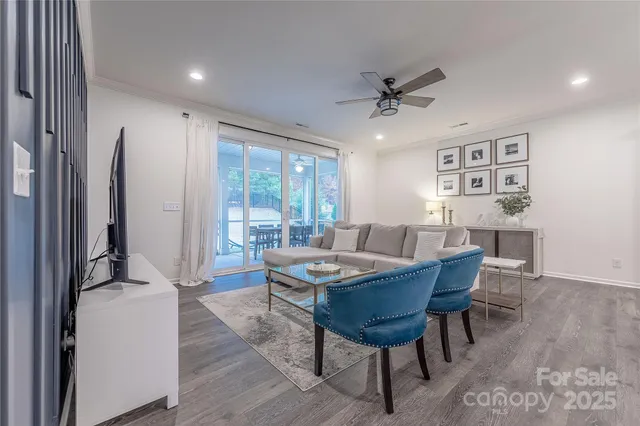 a living room with furniture and a view of kitchen