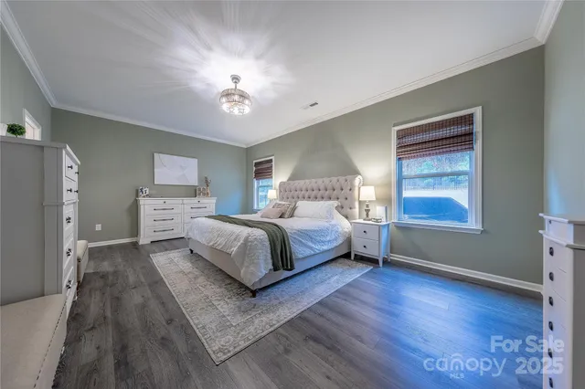 a bedroom with a large bed and a chandelier