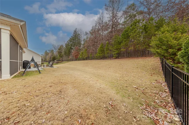 a view of a house with a yard and wooden fence