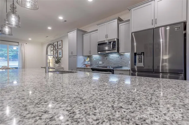 a large kitchen with kitchen island a sink stainless steel appliances and cabinets