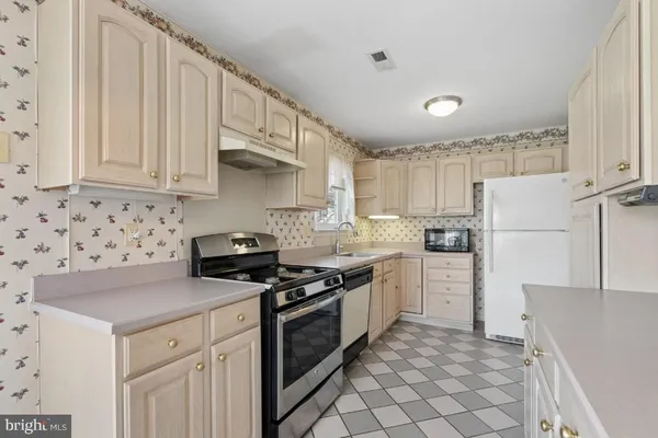 a kitchen with stainless steel appliances a stove a sink and a refrigerator