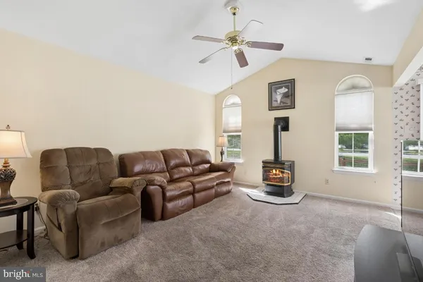 a living room with furniture ceiling fan and a window