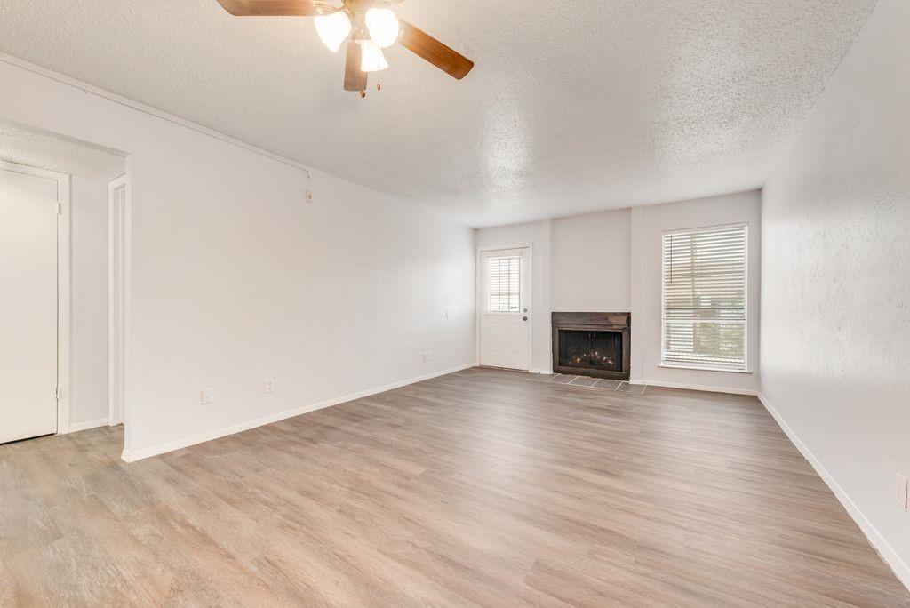 5514 Boca Raton Boulevard, Unit 438 Fort Worth, TX 76112 - Photo 4 of 25 wooden floor fireplace and windows in an empty room