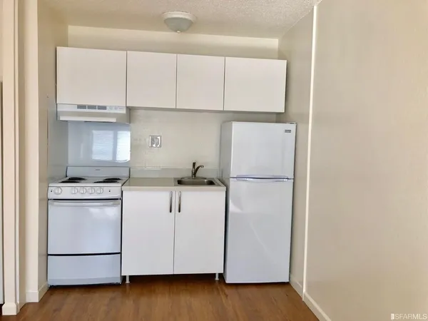 a view of kitchen with wooden floor and electronic appliances