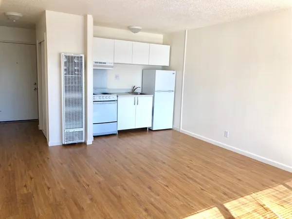 a kitchen with wooden floors and refrigerator