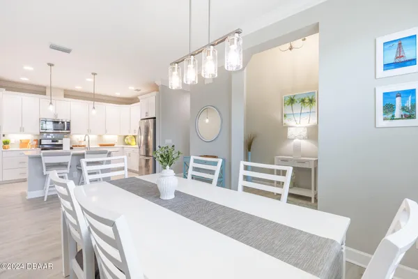 a kitchen with a refrigerator a table and chairs
