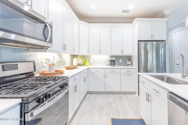 a kitchen with stainless steel appliances granite countertop a sink stove and cabinets