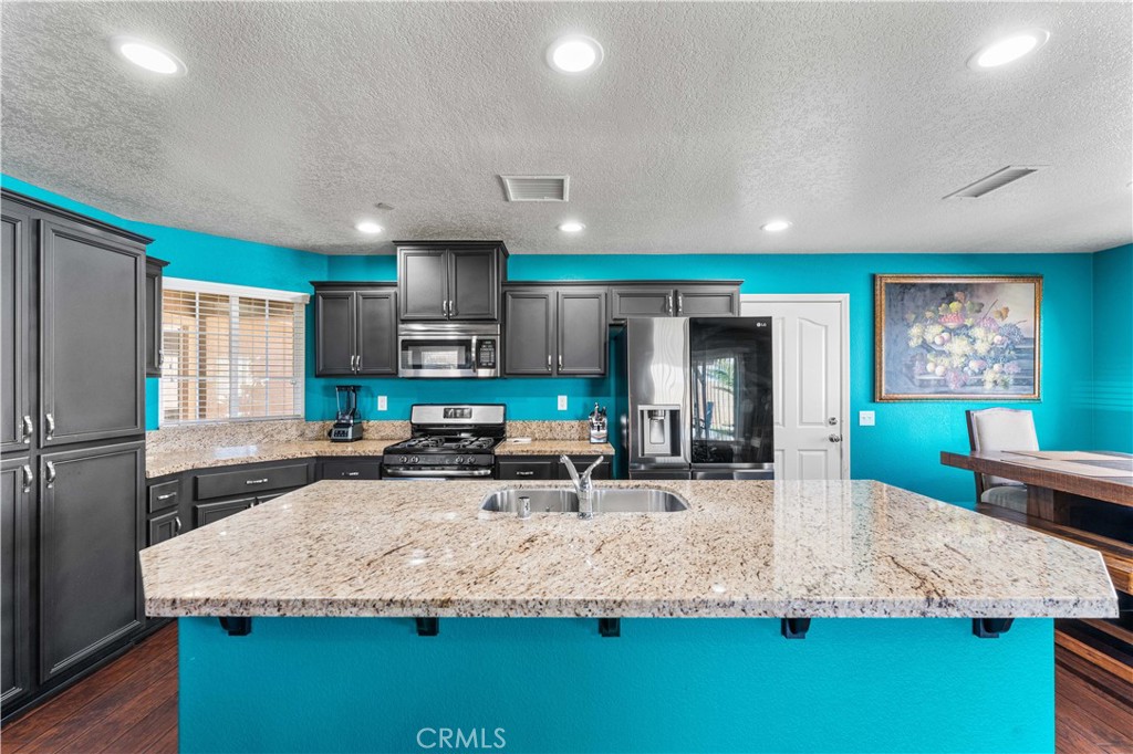 37068 Waltham Place Palmdale, CA 93550 - Photo 14 of 36 a large kitchen with stainless steel appliances granite countertop a large counter top and a stove top oven