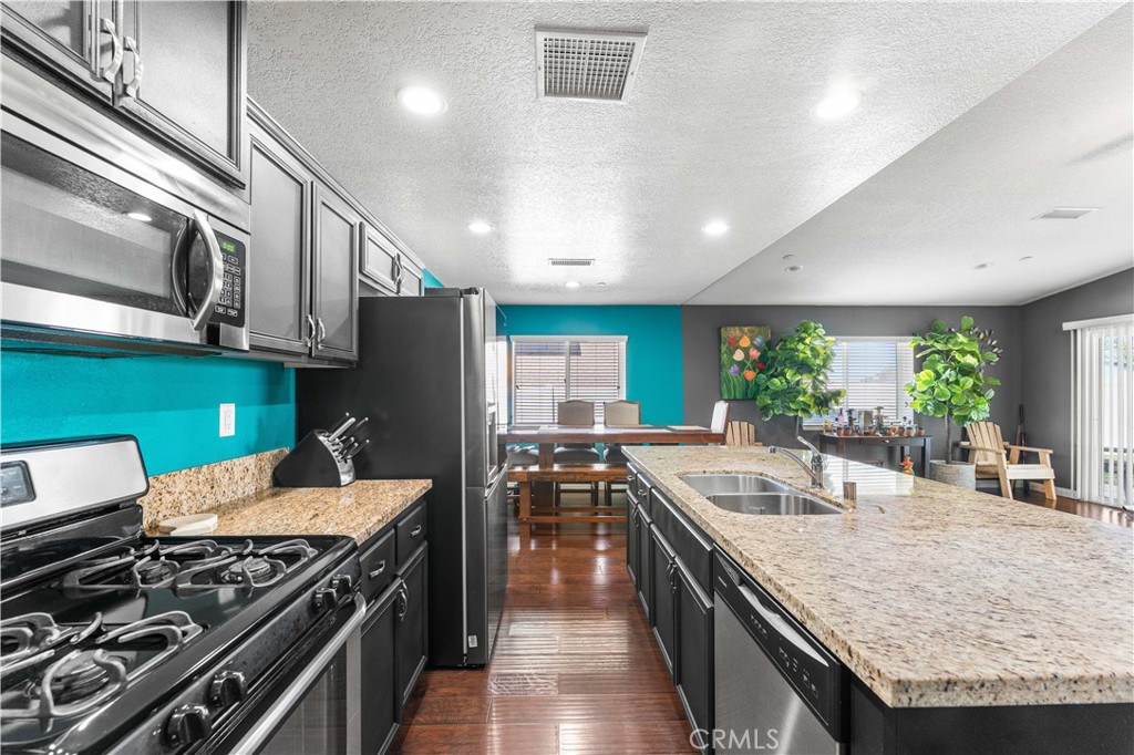37068 Waltham Place Palmdale, CA 93550 - Photo 16 of 36 a kitchen with stainless steel appliances granite countertop a stove and a refrigerator
