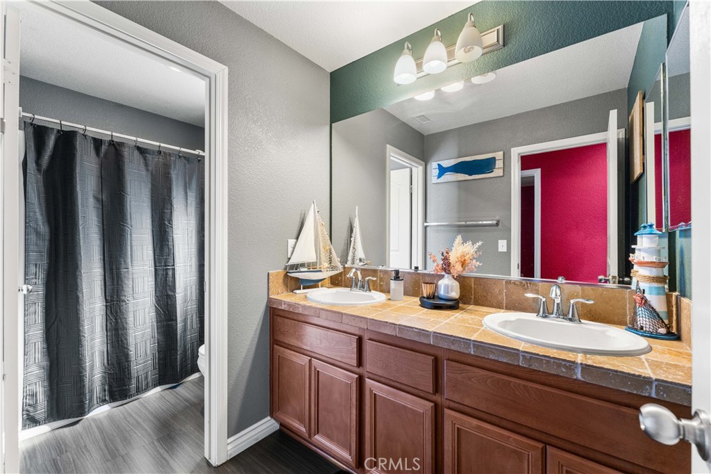 37068 Waltham Place Palmdale, CA 93550 - Photo 29 of 36 a bathroom with double vanity and a mirror