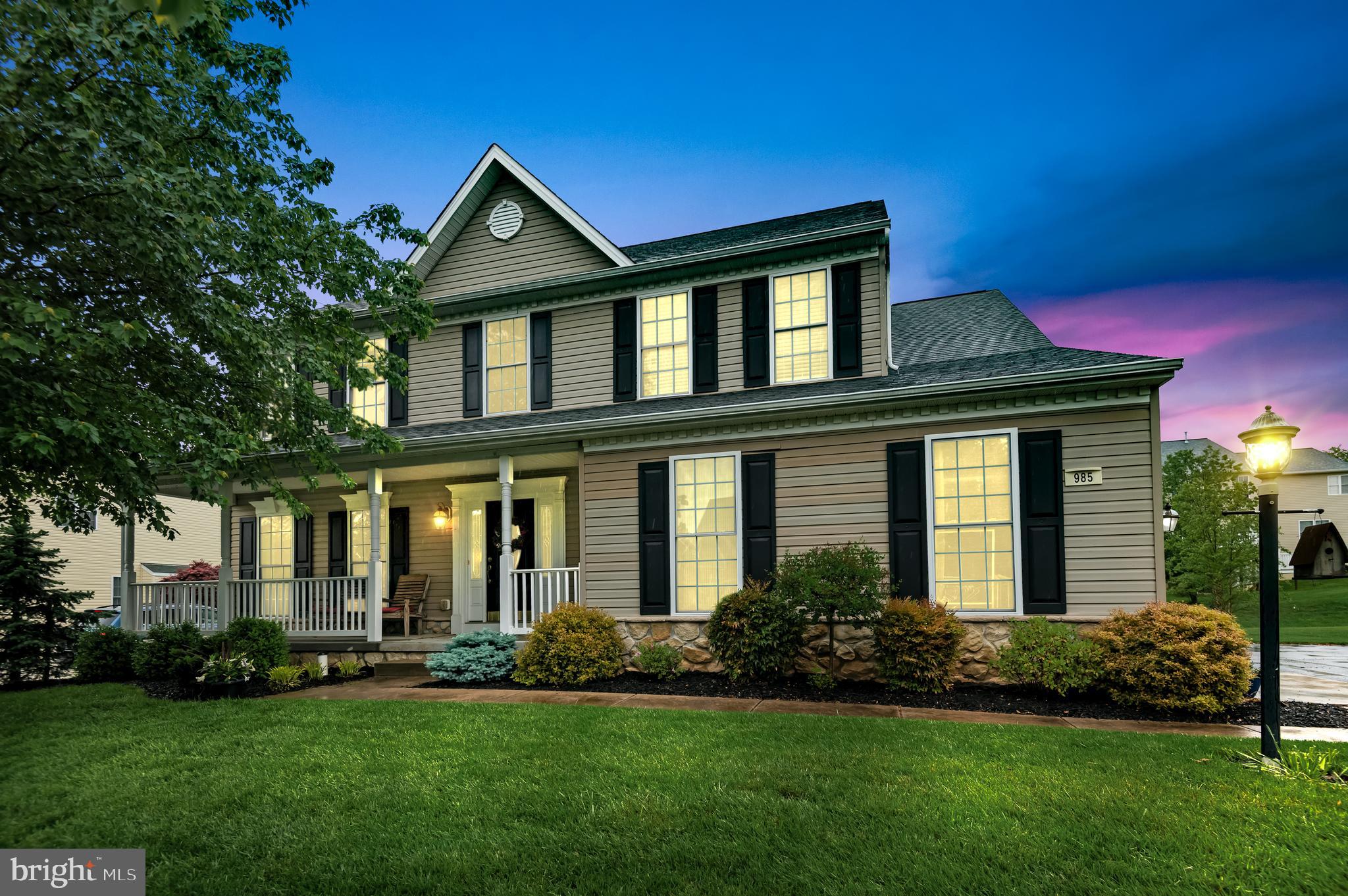 a front view of a house with a garden and plants