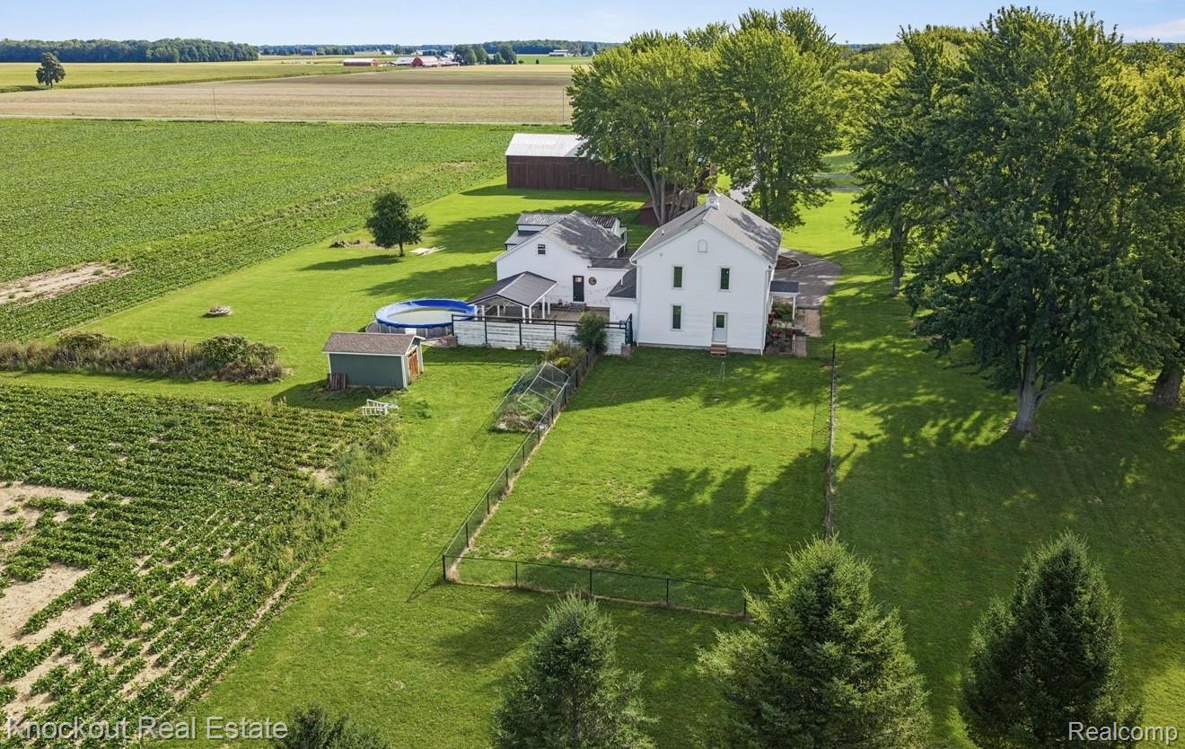 5750 Maple Road Frankenmuth, MI 48734 - Photo 58 of 60 Expansive green lawn surrounds a white two-story residence with a rear deck