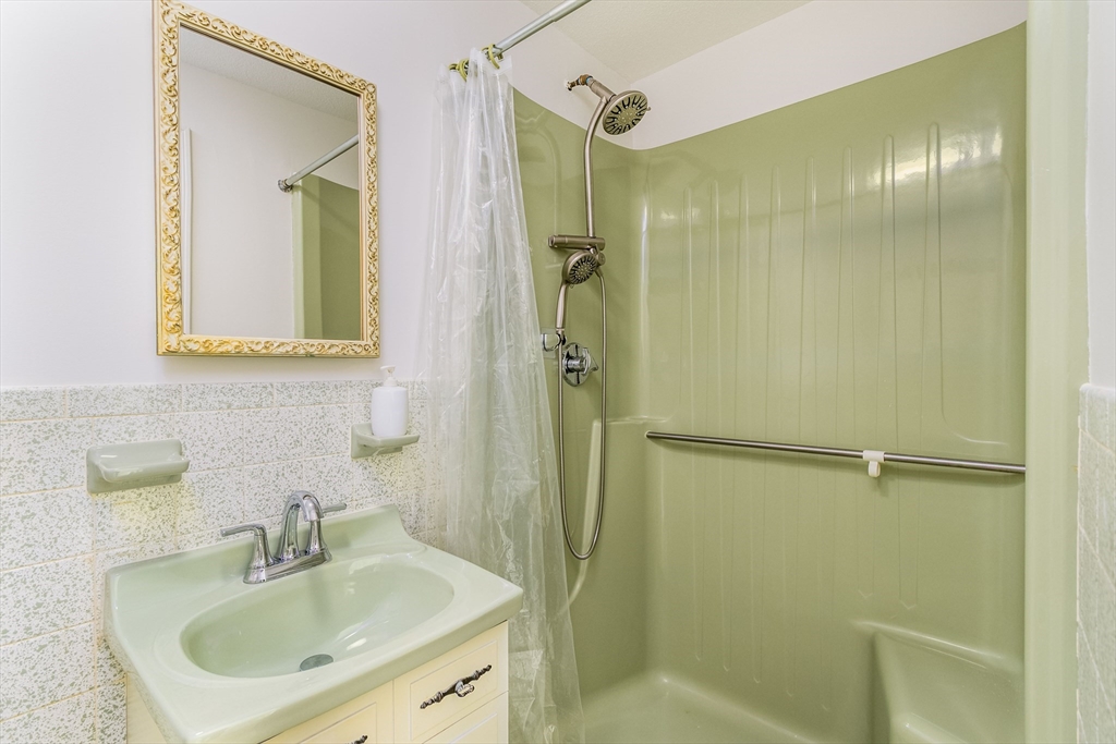 64 McNamara Road Yarmouth, MA 02673 - Photo 11 of 28 a bathroom with a shower sink and mirror