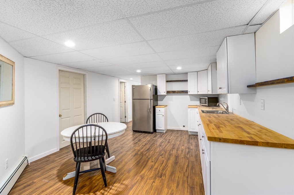 64 McNamara Road Yarmouth, MA 02673 - Photo 17 of 28 a kitchen with stainless steel appliances granite countertop a table chairs sink and cabinets