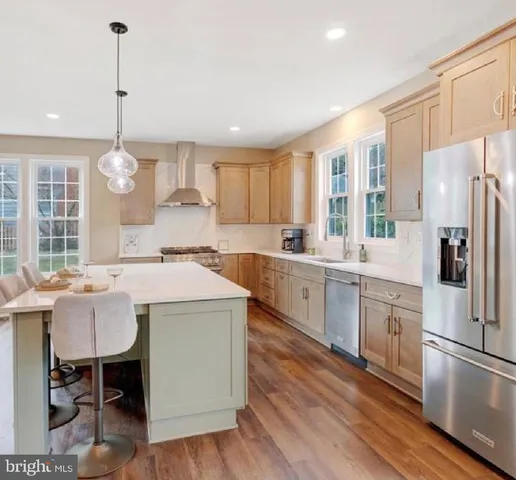 a kitchen that has a lot of cabinets a island and appliances in it