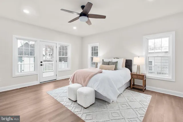 an empty room with wooden floor closet and windows