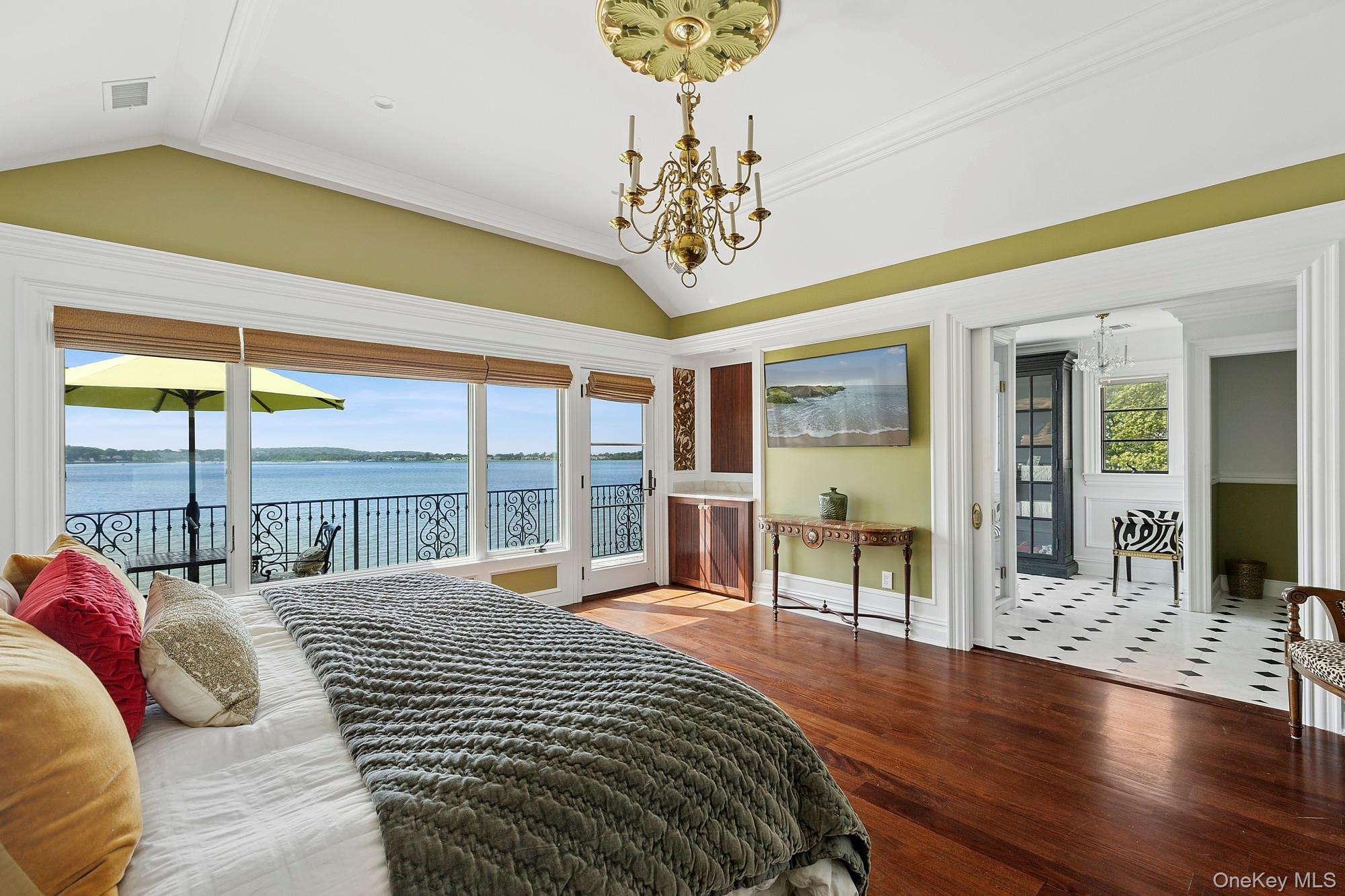 353 Centre Island Road Oyster Bay, NY 11771 - Photo 14 of 34 a bedroom with a large bed and a chandelier