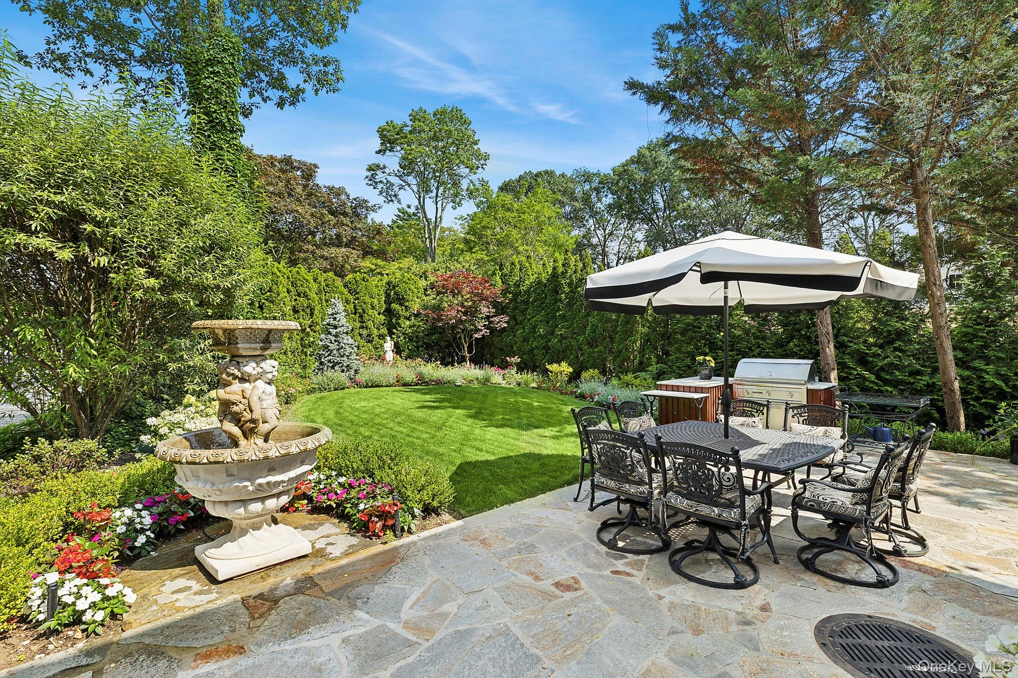 353 Centre Island Road Oyster Bay, NY 11771 - Photo 25 of 34 a view of a patio with a table and chairs under an umbrella