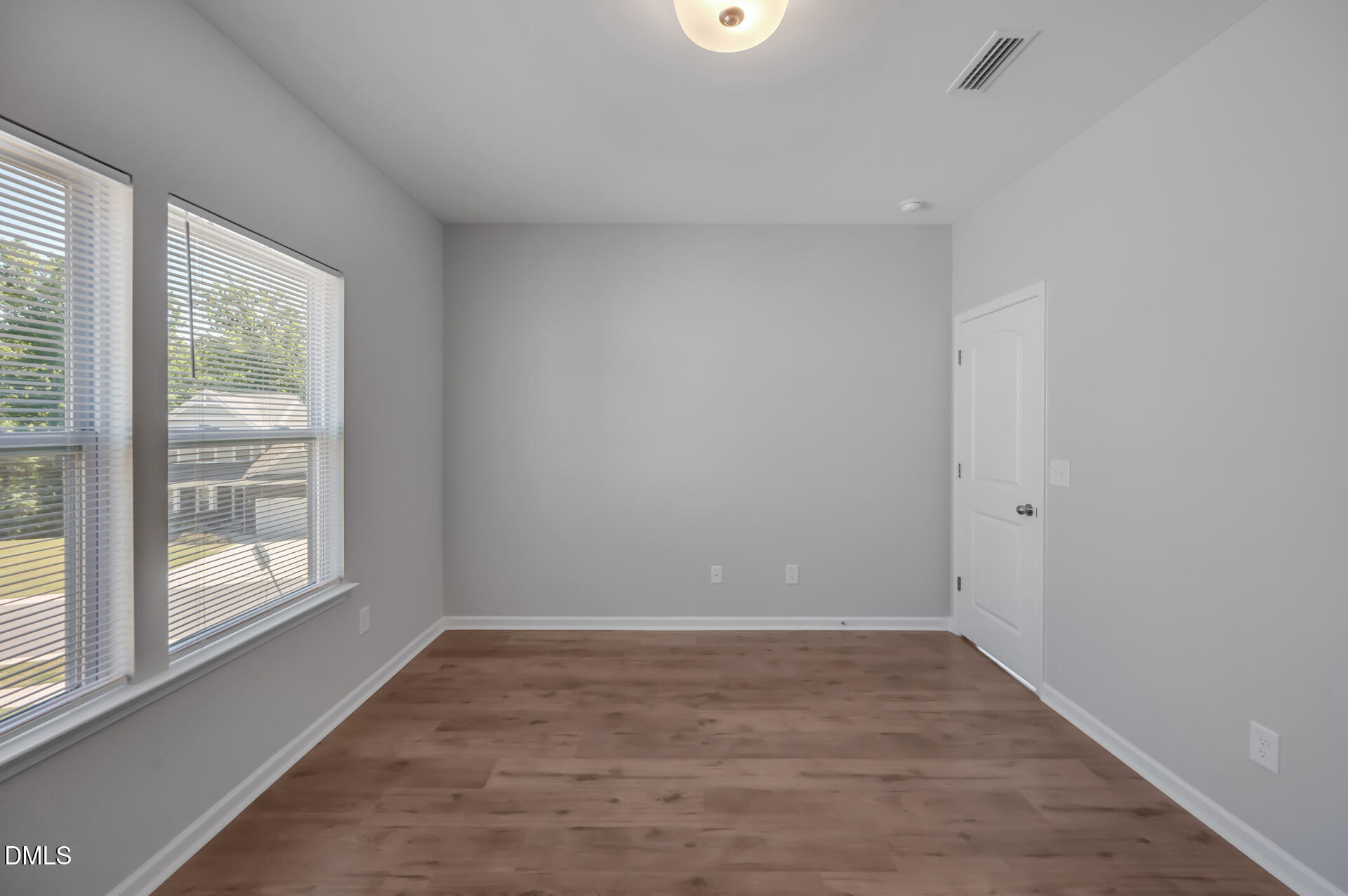 5406 Ripplebrook Drive Durham, NC 27712 - Photo 28 of 37 a view of an empty room with wooden floor and a window