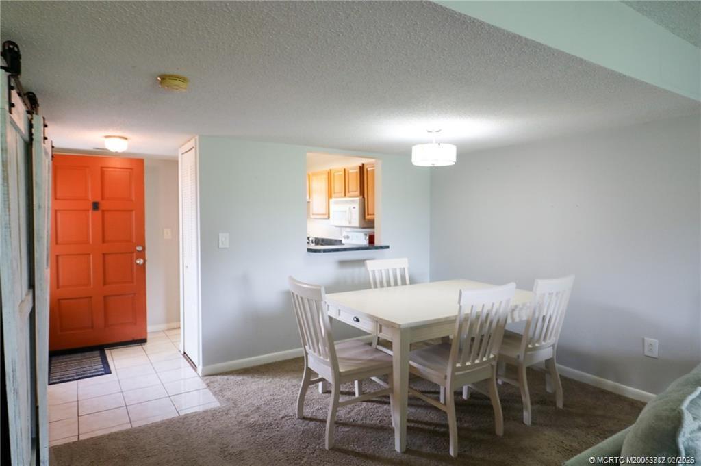 5433 Southeast Miles Grant Road, Unit 203 Stuart, FL 34997 - Photo 3 of 15 a dining room with furniture and window