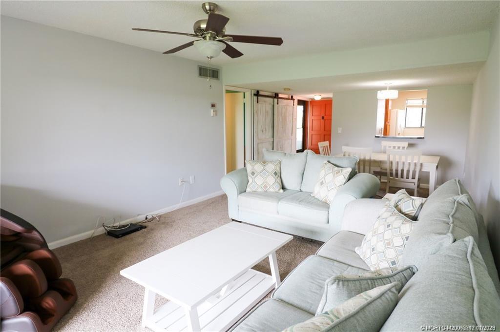 5433 Southeast Miles Grant Road, Unit 203 Stuart, FL 34997 - Photo 5 of 15 a living room with furniture and a window