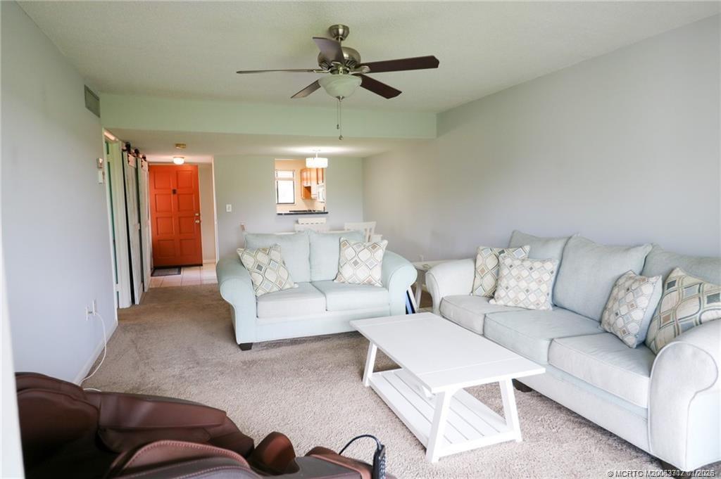 5433 Southeast Miles Grant Road, Unit 203 Stuart, FL 34997 - Photo 7 of 15 a living room with furniture a couch and a chandelier