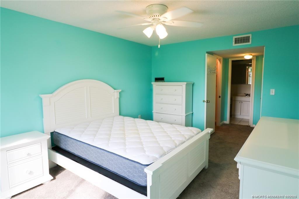 5433 Southeast Miles Grant Road, Unit 203 Stuart, FL 34997 - Photo 10 of 15 a living room with a bed and a chandelier
