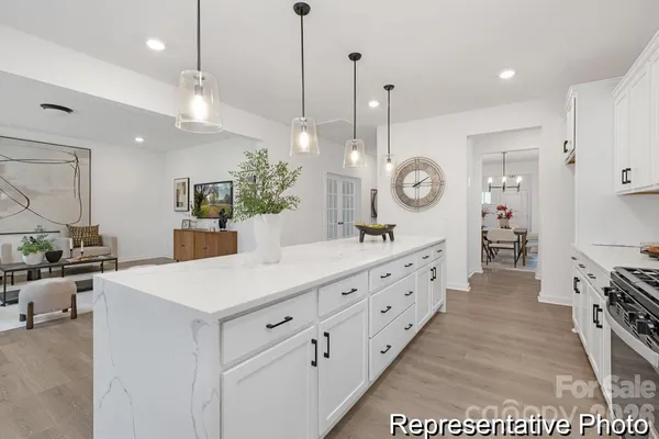 a large kitchen with kitchen island a stove a sink a center island a stove and a wooden floors