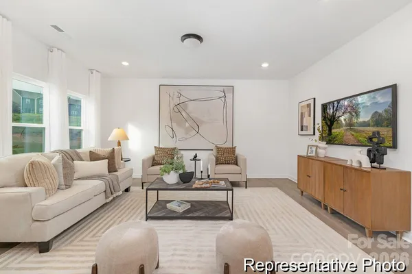 a living room with furniture a flat screen tv and a table