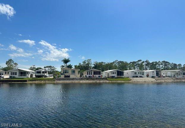 398 Leopard Lane, Unit 398 Naples, FL 34114 - Photo 12 of 50 a view of a lake with boats and trees in the background