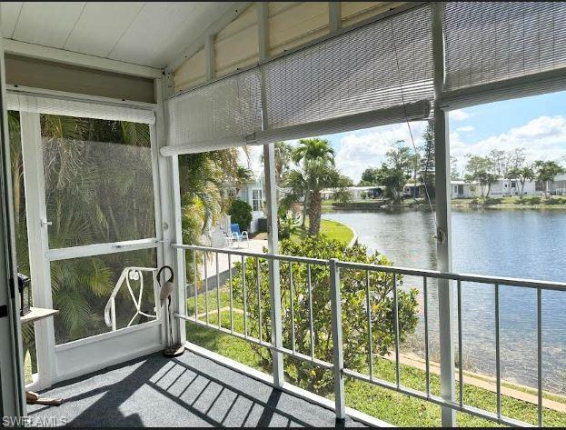 398 Leopard Lane, Unit 398 Naples, FL 34114 - Photo 19 of 50 a view of a balcony with floor to ceiling windows with wooden floor