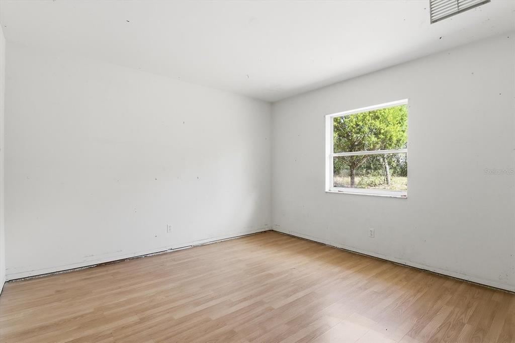 5120 East Hopp Lane Inverness, FL 34452 - Photo 16 of 26 an empty room with wooden floor and windows