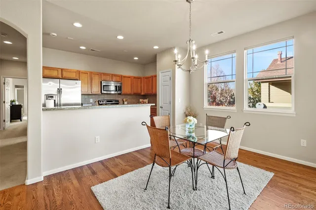 a dining room filled chandelier and wooden floor