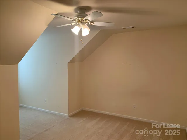 an empty room with a chandelier fan