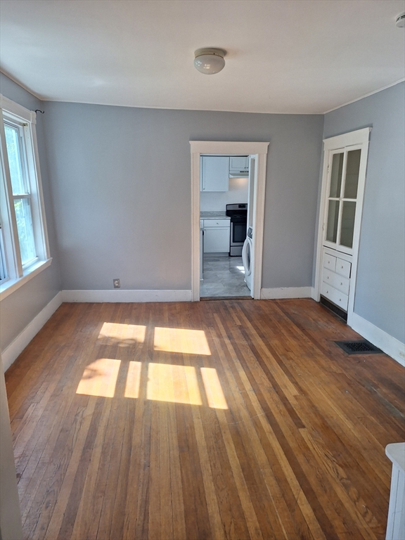 85 Lower E Street, Unit 2 Dedham, MA 02026 - Photo 13 of 13 an empty room with wooden floor and windows