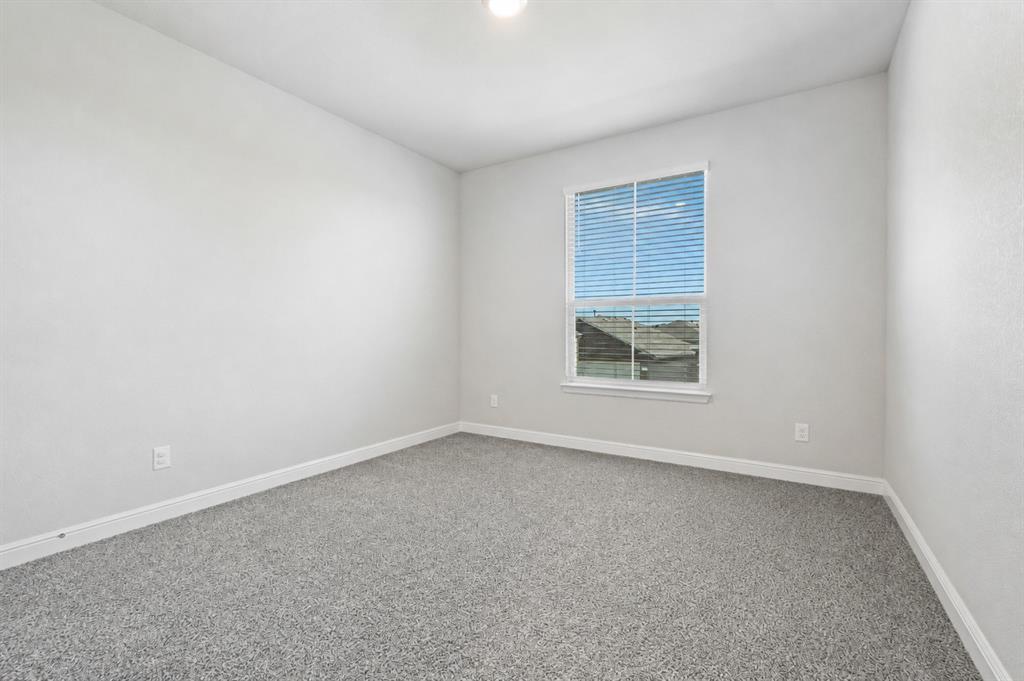 1112 Croxley Way Justin, TX 76247 - Photo 12 of 18 Bright room featuring a single window with blinds, light gray wall paint, white trim, and gray speckled carpet