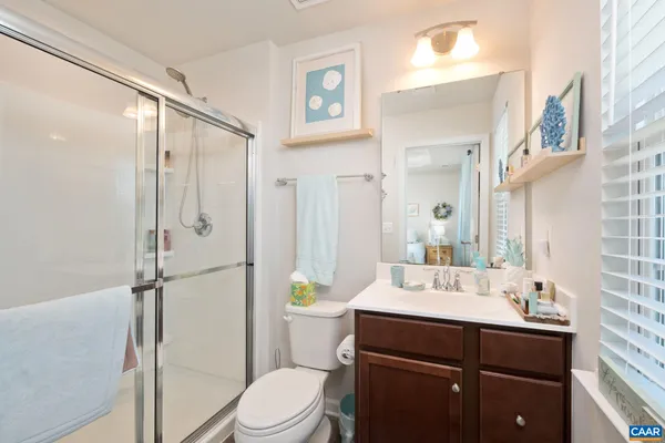 a bathroom with a sink toilet a mirror and shower