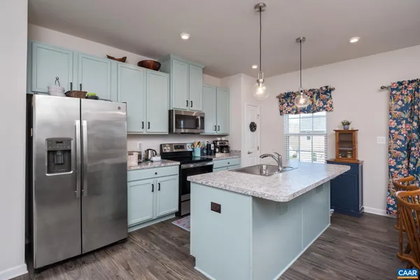 a kitchen with a sink stainless steel appliances and white cabinets
