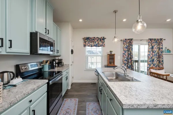a kitchen with granite countertop a sink a counter space appliances and cabinets
