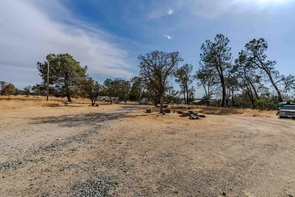 a view of dirt field with trees