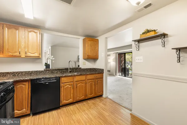a large kitchen with stainless steel appliances granite countertop a sink and cabinets with wooden floor