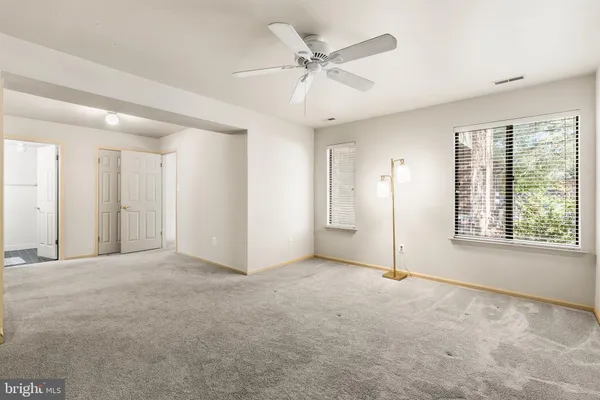 an empty room with fan and windows