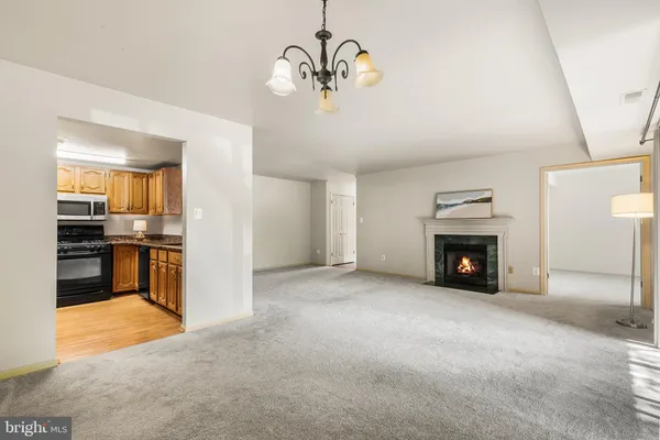 a view of empty room with a fireplace and a chandelier