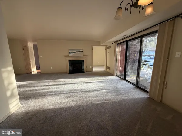a view of an empty room with a fireplace and a window