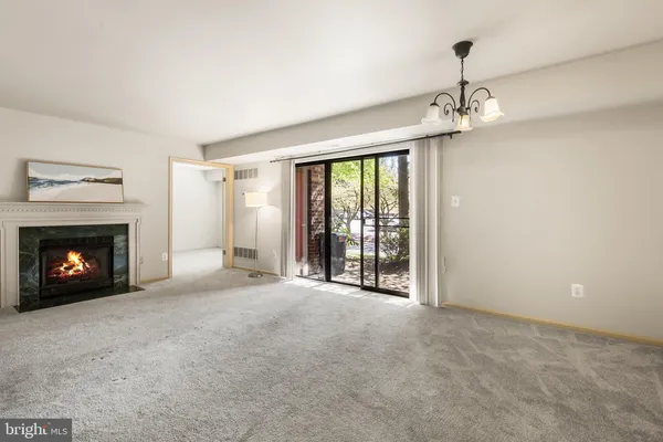 a view of an empty room with a fireplace and a window