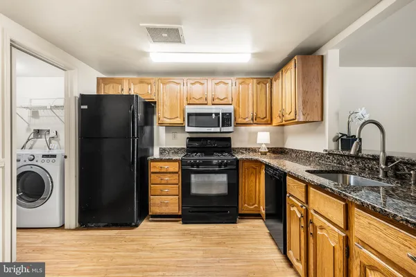 a kitchen with stainless steel appliances granite countertop a refrigerator stove and sink