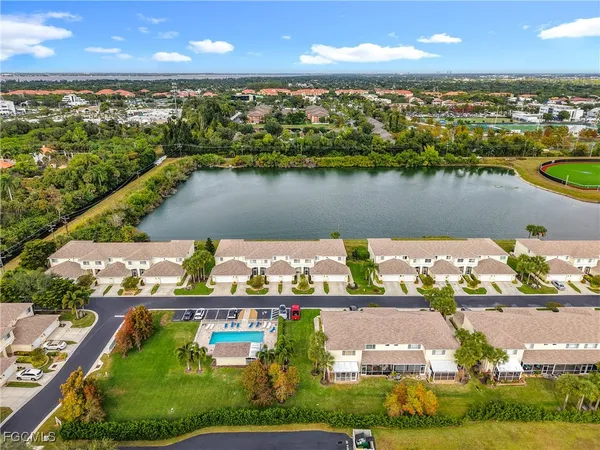 an aerial view of residential houses with outdoor space and lake view